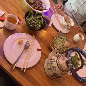 Hou Wei - a wooden table with plates of food on it - Chinese Near Me - Houston, Texas Hou Wei - a wooden table with plates of food on it - Chinese Near Me - Houston, Texas