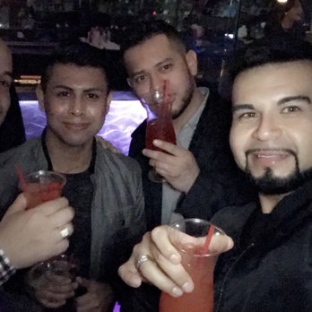Kaliente - a group of men at a bar - Dance Clubs Near Me - Dallas, Texas