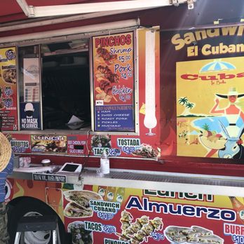 Sandwiches El Cubano - a man standing in front of a food truck - Cuban Near Me