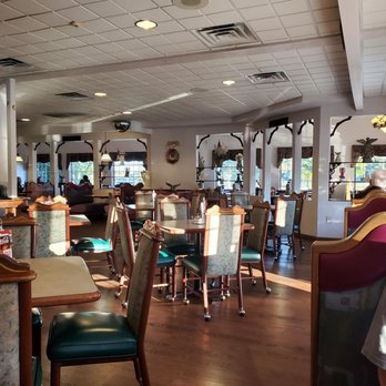 Angel's Restaurant - Restaurant - A family restaurant interior with multiple tables and chairs, windows with curtains, and some patrons seated, illuminated by natural sunlight. - American Near Me - Appleton, Wisconsin
