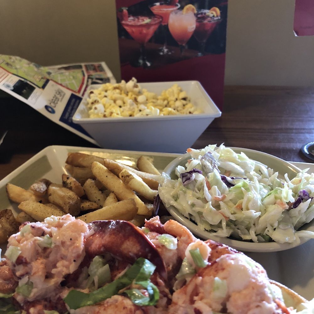 Lobster roll with sides of slaw and fries