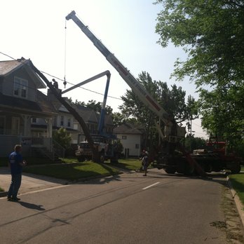 J&M Tree Service - a tree being lifted by a crane - Tree Services Near Me - Flint, Michigan