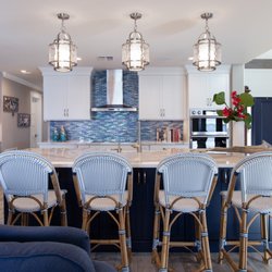 Persimmon Interior Design - Coastal, modern kitchen with a navy island and white shaker cabinets creates a breezy welcoming area for a crowd to gather.