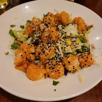 Houlihan's - Shrimp appetizer - Fried shrimp topped with black and white sesame seeds are arranged on a bed of shredded lettuce and vegetables. - Bars Near Me - Dubuque, Iowa