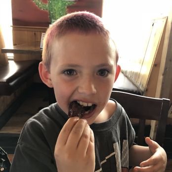 Wild Wing Whitby - a young boy eating a donut - Chicken Wings Near Me - Whitby, Ontario Wild Wing Whitby - a young boy eating a donut - Chicken Wings Near Me - Whitby, Ontario
