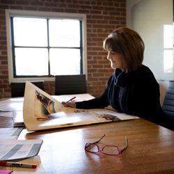 Page Design Group - Production Manager Sherril reviewing client proofs