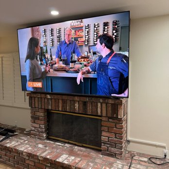 Grindlex Home Services - Massive flatscreen mounted above a rustic brick fireplace -- perfectly centered, cables hidden, showroom-clean finish from every angle. - TV Mounting Near Me Grindlex Home Services - Massive flatscreen mounted above a rustic brick fireplace -- perfectly centered, cables hidden, showroom-clean finish from every angle. - TV Mounting Near Me