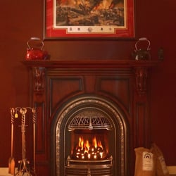 Wooden Sun - Valor Portrait gas fireplace with coal basket and windsor arch front and Fires of Tradition mantle.