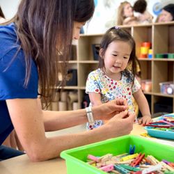 KidStream - A museum educator assists a guest with a hands-on building activity in the Makerspace.
