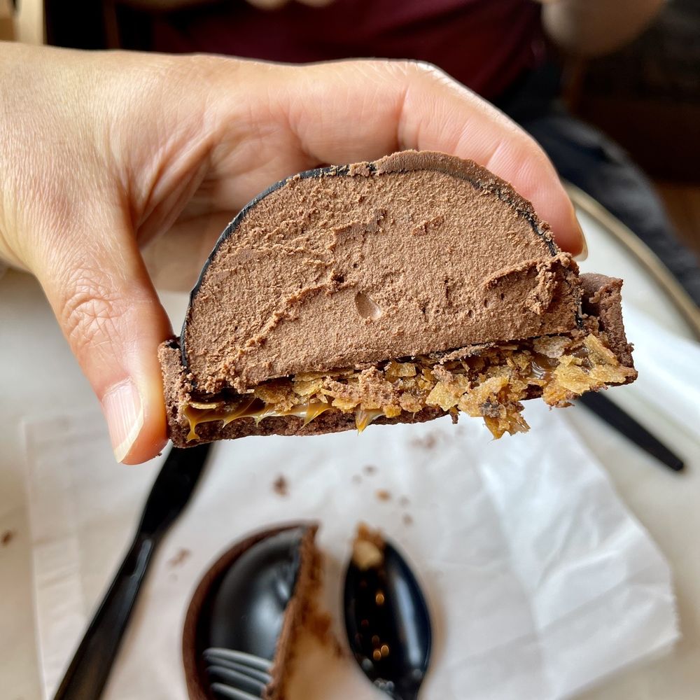 Upper Crust Baking - a person holding a piece of chocolate cake - Bakeries Near Me - Winters, California Upper Crust Baking - a person holding a piece of chocolate cake - Bakeries Near Me - Winters, California