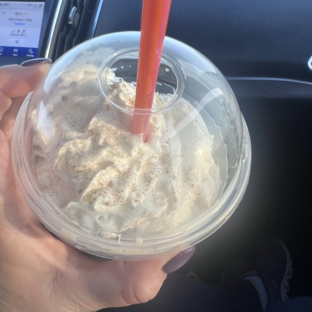 a hand holding a plastic cup of ice cream a hand holding a plastic cup of ice cream
