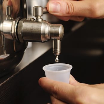 The Olive Grove - a person filling a cup from a faucet - Olive Oil Near Me - Mendota Heights, Minnesota The Olive Grove - a person filling a cup from a faucet - Olive Oil Near Me - Mendota Heights, Minnesota
