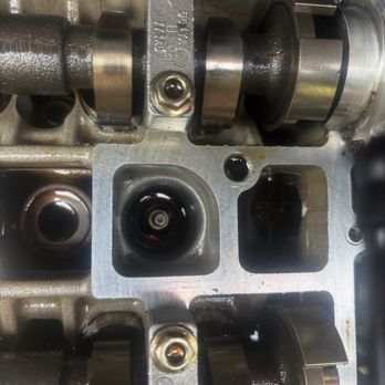 The Cozy Emblem - A spark plug filled with oil - Auto Detailing Near Me