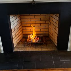 Portland Chimney - Firebox Rebuild - Using new buff firebrick. Homeowner having a beautiful fire in their fireplace.