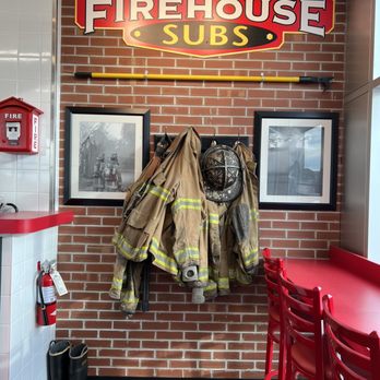 Firehouse Subs - a fireman's coat hanging on a brick wall - Sandwiches Near Me - Burlington, Ontario
