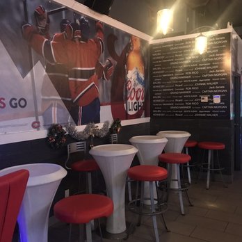 Bar Monti - a row of stools in front of a mural of a hockey player - Sports Bars Near Me - Montreal, Quebec Bar Monti - a row of stools in front of a mural of a hockey player - Sports Bars Near Me - Montreal, Quebec