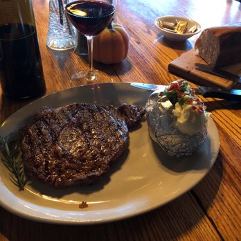 Molly Butler’s - Ribeye with cute sprig if rosemary and baked potato - Steakhouses Near Me - Greer, Arizona