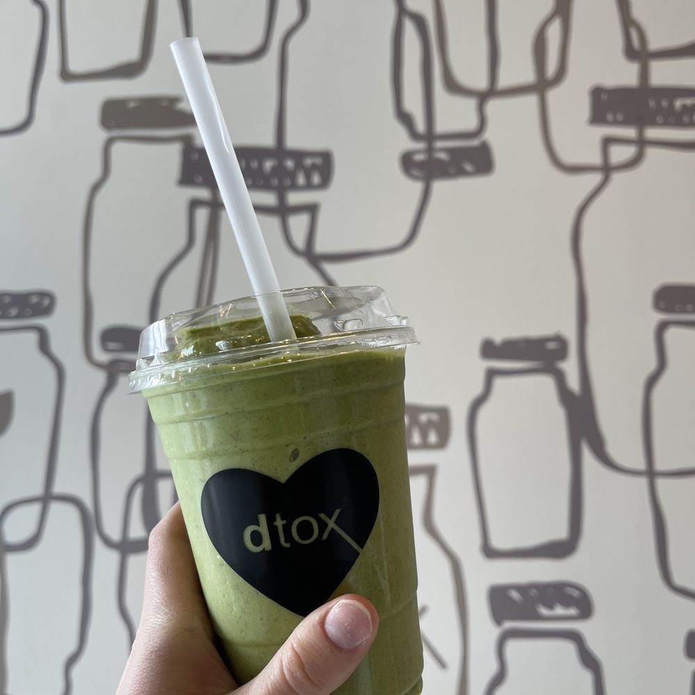 a hand holding a green smoothie a hand holding a green smoothie