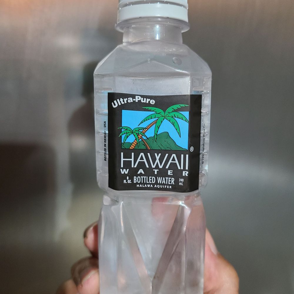 a hand holding a bottle of water a hand holding a bottle of water
