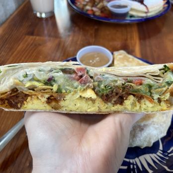 Mis Tacones - Crunchwrap closeup. Hand for size comparison - Vegan Near Me - Portland, Oregon Mis Tacones - Crunchwrap closeup. Hand for size comparison - Vegan Near Me - Portland, Oregon