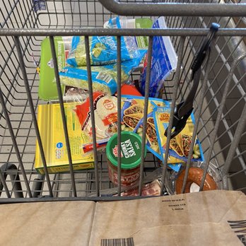 ALDI - a shopping cart full of groceries - A grocery cart contains frozen foods, canned goods, a bag of bacon, and other grocery items, viewed from above. - Grocery Near Me - Laurel, Maryland