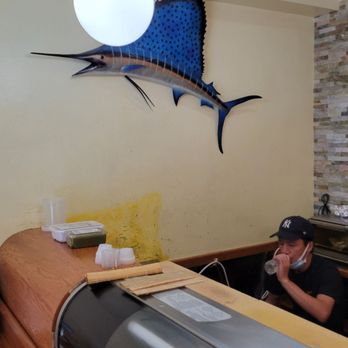 Abi Sushi - a man sitting at a counter - Sushi Bars Near Me - Astoria, New York