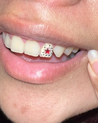 Tooth Gems - What are Tooth Gems?
Tooth Gems are a type of dental jewelry that are applied to the surface of a tooth. They offer a playful and artistic way to self-express. This distinctive style of body art is less invasive than piercings or tattoos, enabling you to experiment with a range of designs and styles.

What type of gems are used?
I carry a variety of gems such as Swarovski, Preciosa, genuine opal, dental acrylic micros and solid 18k white or yellow gold. All jewelry used is always lead-free, copper-free, non-toxic and safe for oral use.

How are they applied?
Tooth gems are bonded using professional dental materials & equipment, similar to the way dentists would apply braces. The process is 100% non-invasive, painless & safe for teeth.

Are Tooth Gems for everyone?
Anyone with healthy live teeth can wear tooth gems. People with veneers or crowns are not recommended to wear tooth gems. Tooth gems may be applied around retainers or braces but it's recommended to check with your dentist first.

How long do they last?
Longevity depends on your enamel as well as dental care. Depending on the individual, tooth gems can last from 6 months to 1 year. I offer a 1 time fix 14 day guarantee for all gems that may fall off prematurely.

How are they removed?
If your gem falls off or you decide you no longer want yours, please see a dentist for removals. Most dentist will remove gems free during your routine cleanings.