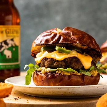 Dina's Bistro - a cheeseburger on a plate with a bottle of beer in the background - New American Near Me - Toms River, New Jersey