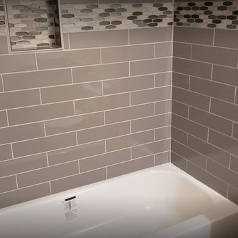 Improving Construction - a bathroom with a toilet and bathtub - General Contractors Near Me Improving Construction - a bathroom with a toilet and bathtub - General Contractors Near Me