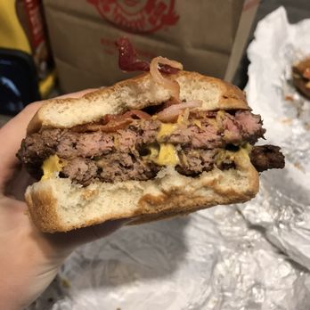 Wendy's - a hand holding a half eaten sandwich - Burgers Near Me - New Smyrna Beach, Florida Wendy's - a hand holding a half eaten sandwich - Burgers Near Me - New Smyrna Beach, Florida