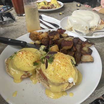 Cafe Topes - Eggs Benedict with Seasoned Potatoes pulled pork Benedict across table. Passion fruit mimosa and bloody - Coffee & Tea Near Me - Carlsbad, California