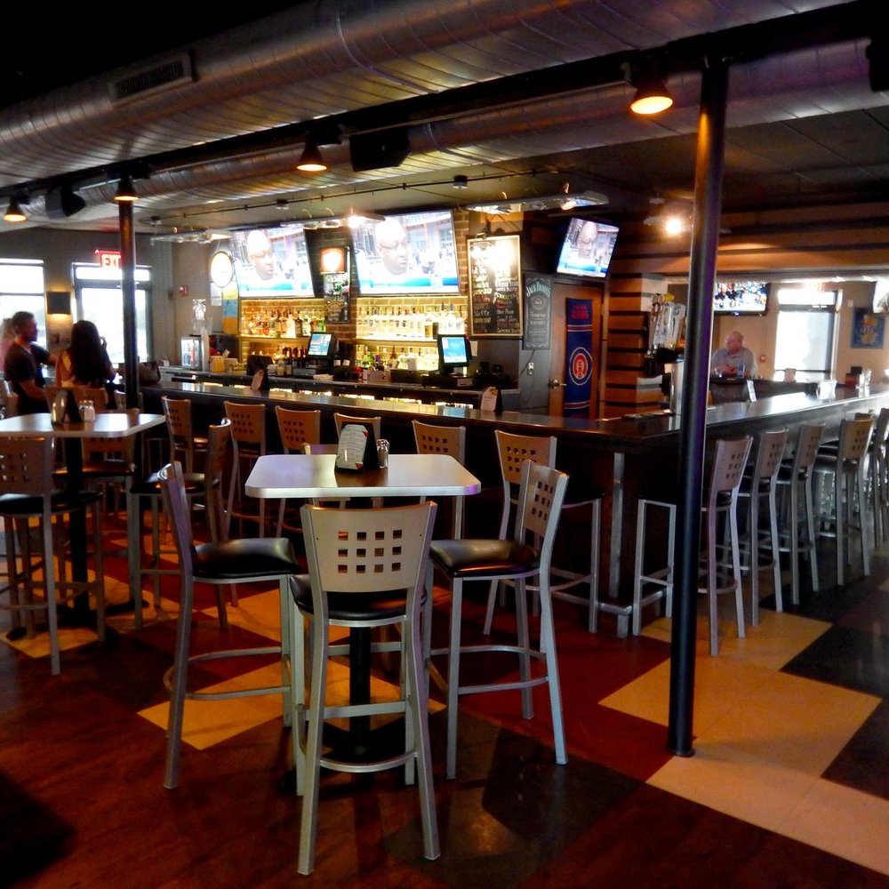 Jimmy D's District - Here is the bar which wraps around to the other side on the left. That is where the main seating is. - American Near Me - Arlington Heights, Illinois Jimmy D's District - Here is the bar which wraps around to the other side on the left. That is where the main seating is. - American Near Me - Arlington Heights, Illinois