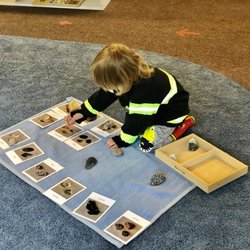 Montessori School At Five Canyons - Children like to stretch out on the rugs especially when working on matching activities.