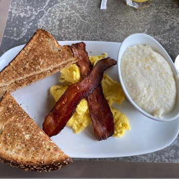 Another Broken Egg Cafe - One egg, bacon, grits, whole grain toast and orange juice (not shown.) - Breakfast & Brunch Near Me - Huntsville, Alabama Another Broken Egg Cafe - One egg, bacon, grits, whole grain toast and orange juice (not shown.) - Breakfast & Brunch Near Me - Huntsville, Alabama
