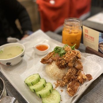 Three Roosters - a plate of food on a table - Thai Near Me - New York, New York Three Roosters - a plate of food on a table - Thai Near Me - New York, New York