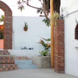 La Bohemia Baja Hotel Pequeño - Whitewashed adobe architecture with lush tropical gardens.