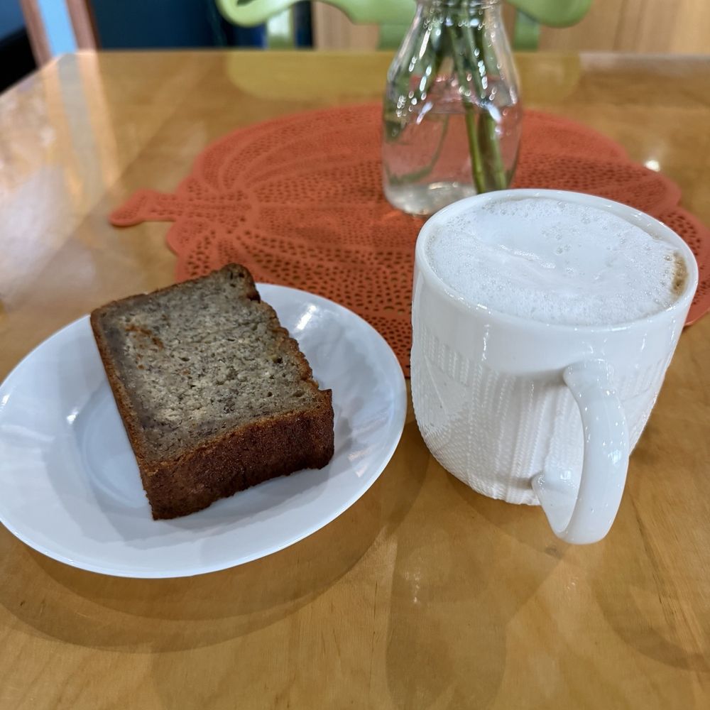 Cappuccino, amazing banana bread on a table with a pumpkin centerpiece and flowers.  The kind of touches that make it special.