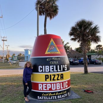 Cibelli's Pizza - a woman standing in front of a giant sign - Pizza Near Me - Satellite Beach, Florida Cibelli's Pizza - a woman standing in front of a giant sign - Pizza Near Me - Satellite Beach, Florida