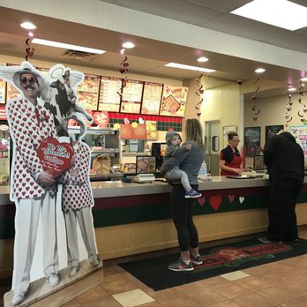 Rocky Rococo - a couple of people standing in front of a counter - Pizza Near Me - Oconomowoc, Wisconsin Rocky Rococo - a couple of people standing in front of a counter - Pizza Near Me - Oconomowoc, Wisconsin