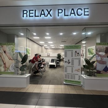 Relax Spa - Entrance - The image shows a spa named 'RELAX PLACE' with a lit sign above the entrance, revealing a reception and treatment area inside. - Massage Near Me - Schaumburg, Illinois