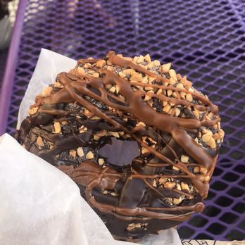 Voodoo Doughnut - Chuckles--classic yeast donut dipped in chocolate frosting, crushed peanuts, hot chocolate powder and caramel & chocolate syrups - Donuts Near Me - Portland, Oregon Voodoo Doughnut - Chuckles--classic yeast donut dipped in chocolate frosting, crushed peanuts, hot chocolate powder and caramel & chocolate syrups - Donuts Near Me - Portland, Oregon
