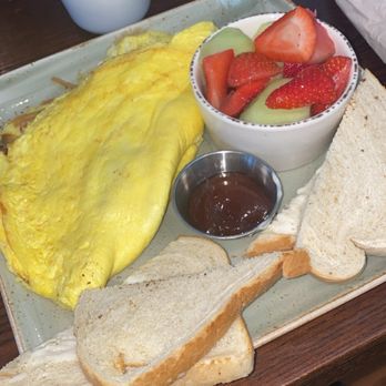 First Watch - Omelet with ham, mushrooms, onions and mozzarella cheese with fruit and sourdough bread on the side. Strawberry jam in the middle. - Breakfast & Brunch Near Me - Boca Raton, Florida