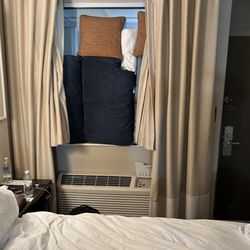 City Loft Hotel - 3am. Trying to use pillows to block hallway lights. Curtains to short to work. Notice how close AC is to bed so freeze or sweat.