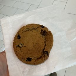 a hand holding a chocolate chip cookie