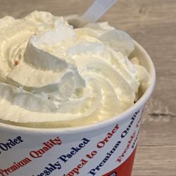 McCool's Ice Cream & Frozen Yogurt - Two scoops with whipped cream & rainbow sprinkles underneath.