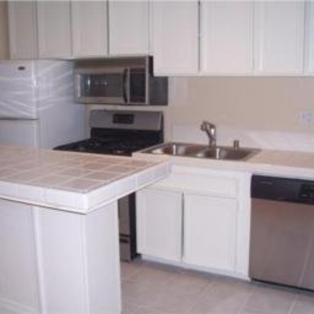 a kitchen with white cabinets and stainless steel appliances a kitchen with white cabinets and stainless steel appliances