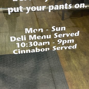 Schlotzsky's - Hours of operation - A sign on a restaurant door lists menu hours, including a deli menu served from 10:30 am to 9 pm, with cinnamon rolls. - Sandwiches Near Me - Spring, Texas