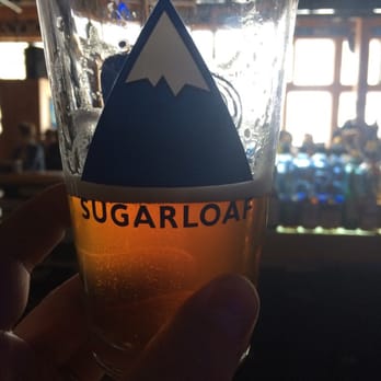Widowmaker Lounge - a hand holding a glass of sugarloaf - Bars Near Me - Carrabassett Valley, Maine