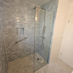 Jeremiah V Solutions - Full bathroom makeover Custom blue tiles, frameless glass, and modern lighting create a sleek, relaxing space. #BathroomRemodel #TileDesign