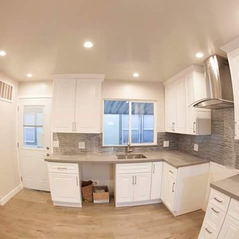JC Construction - a kitchen with white cabinets and a window - General Contractors Near Me JC Construction - a kitchen with white cabinets and a window - General Contractors Near Me